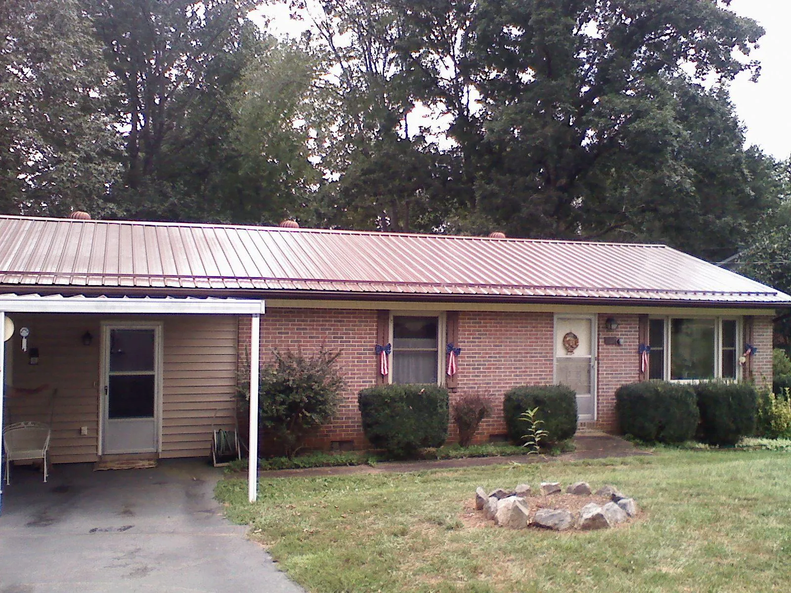 Bronze metal roof and carport on a brick ranch home — Roof Repair work by our crew in Dysart